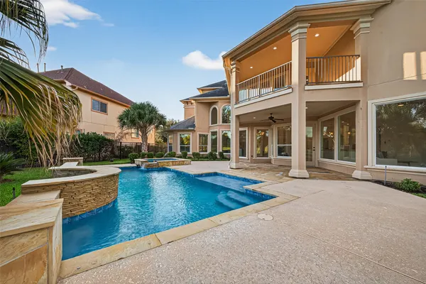 a view of house with swimming pool and outdoor seating