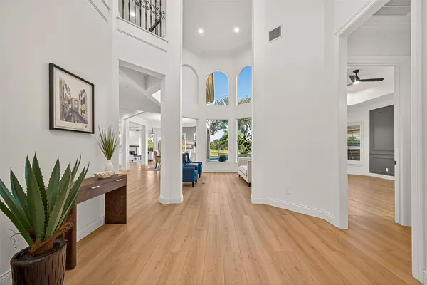 a view of a hallway with wooden floor and a potted plant