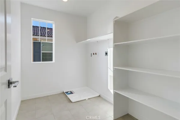 an empty room with a white cabinet and a window