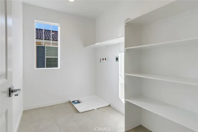 an empty room with a white cabinet and a window