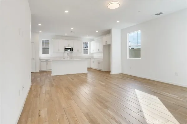 a view of kitchen with wooden floor and electronic appliances
