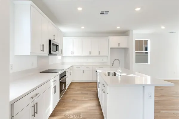 a kitchen with a sink stove top oven and refrigerator