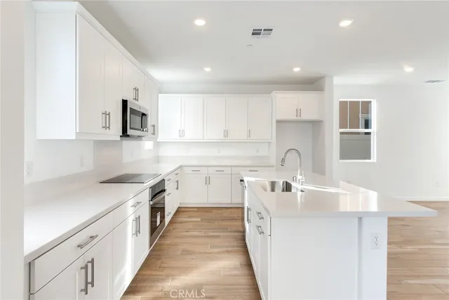 a kitchen with a sink stove top oven and refrigerator
