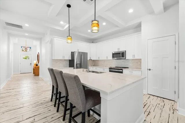 a kitchen with stainless steel appliances granite countertop a sink a stove and a refrigerator