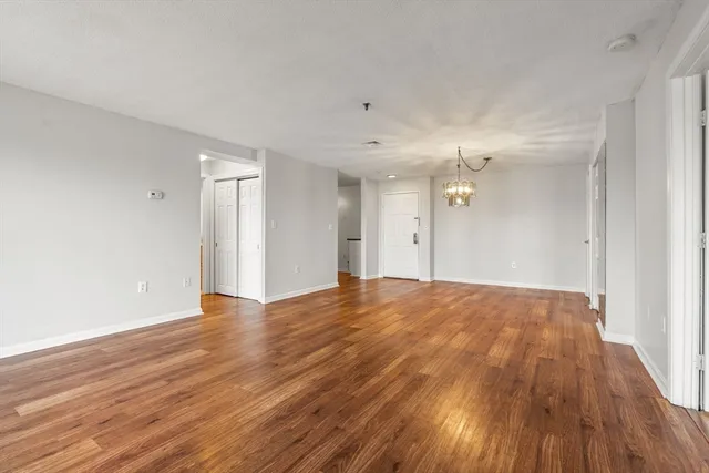 a view of a big room with wooden floor and windows