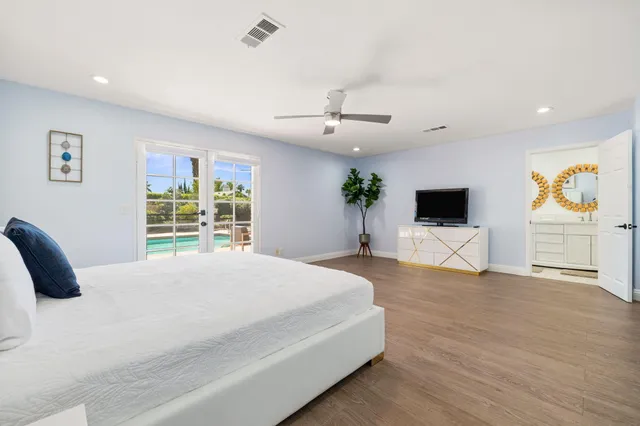 a spacious bedroom with a large bed and a flat screen tv