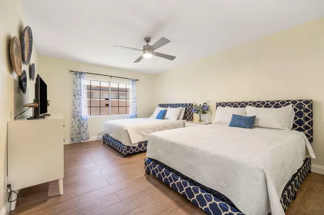 a spacious bedroom with two beds and a window