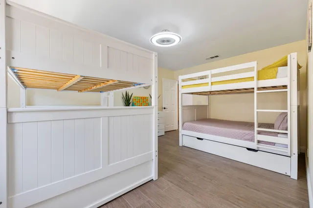 a hallway with white cabinets and wooden floor