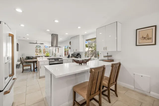a kitchen with a dining table chairs and white stainless steel appliances