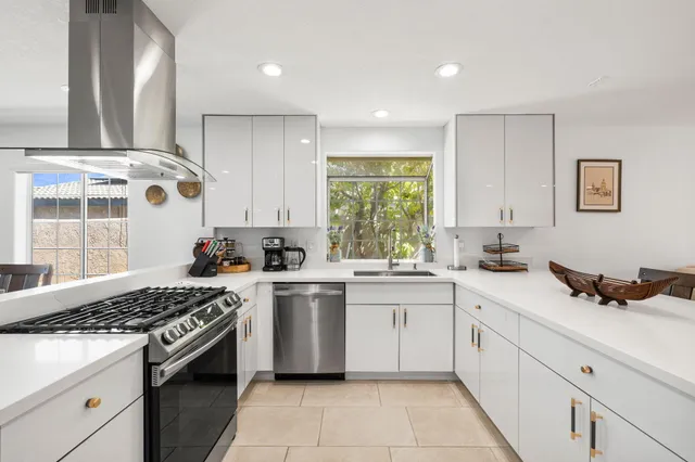 a kitchen with a stove a sink and a window