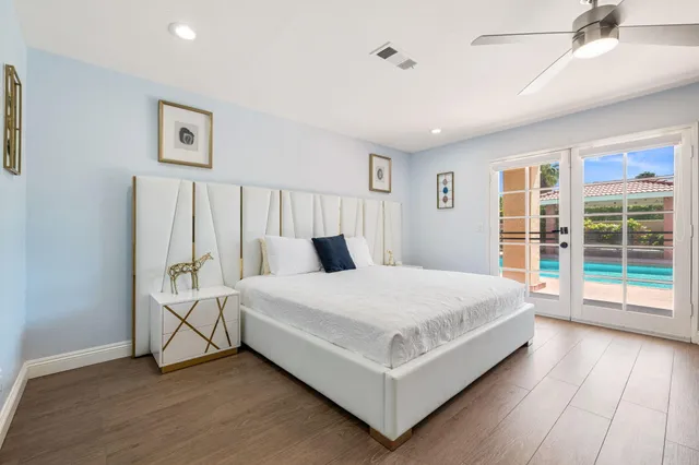 a large white bed sitting in a bedroom next to a window