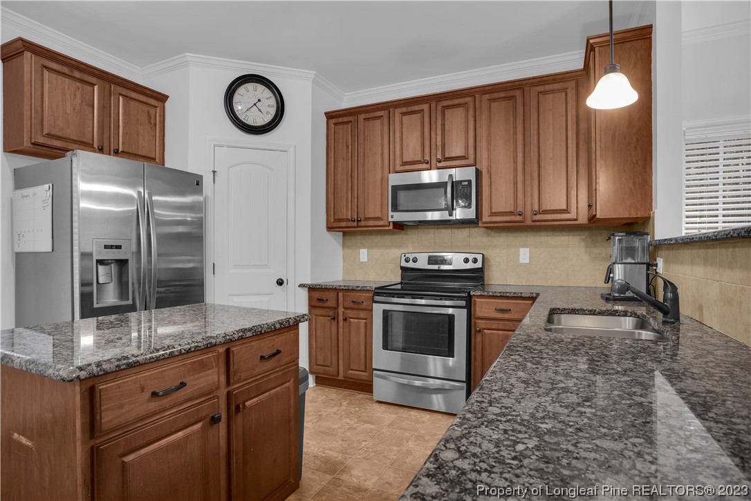 80 Valor Circle Bunnlevel, NC 28323 - Photo 17 of 49 a kitchen with granite countertop a stove top oven microwave and cabinets