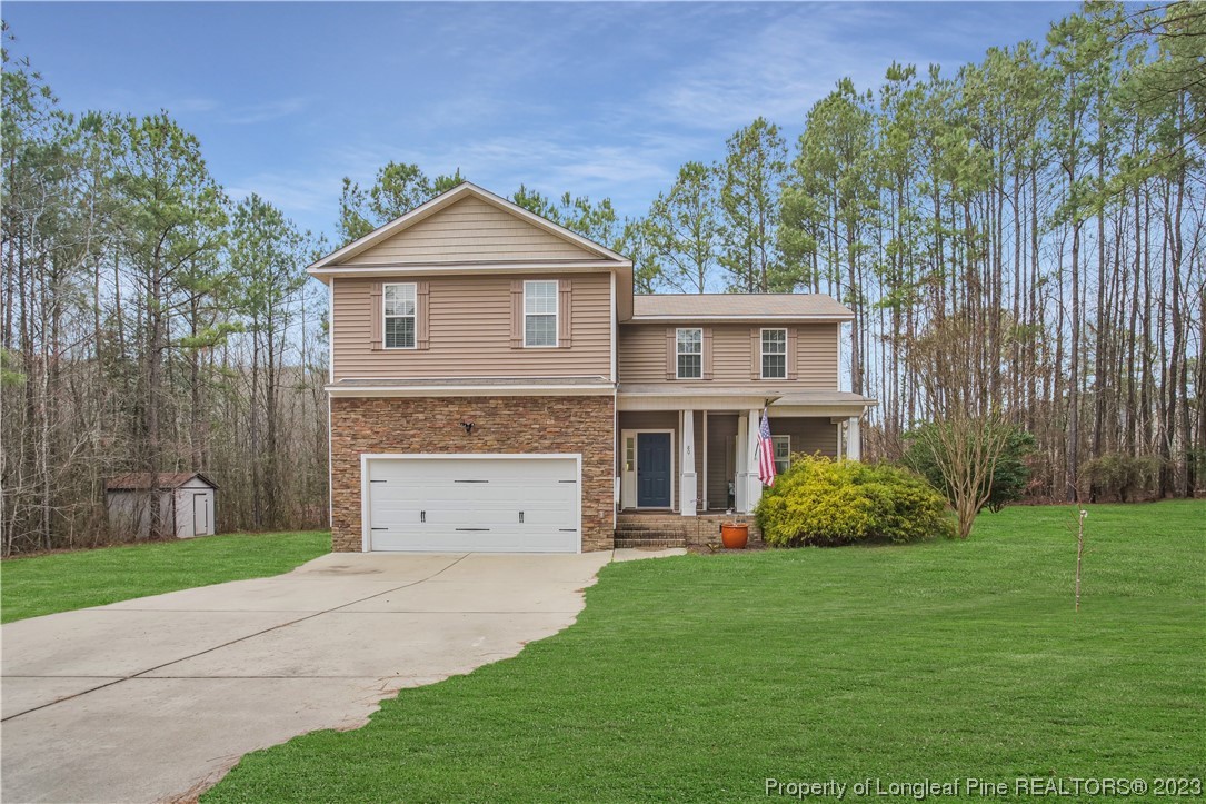 80 Valor Circle Bunnlevel, NC 28323 - Photo 2 of 49 a view of a yard in front of a house with plants and large tree