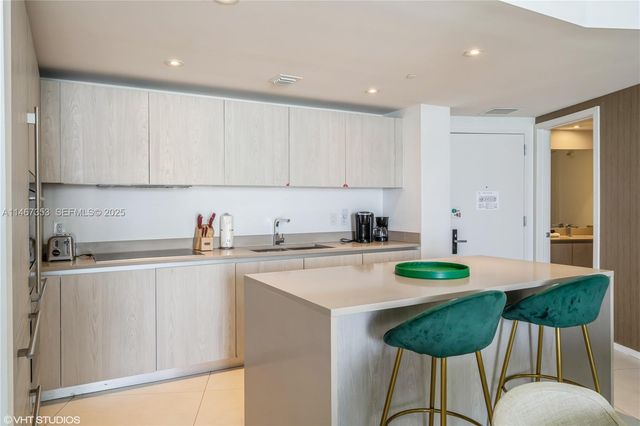a kitchen with stainless steel appliances granite countertop a sink and white cabinets