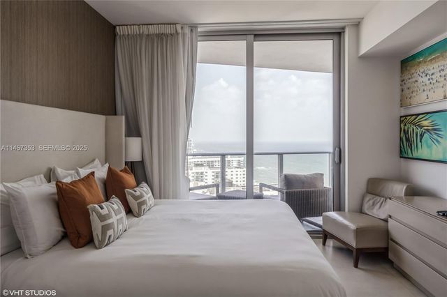 a bedroom with bed and a large window