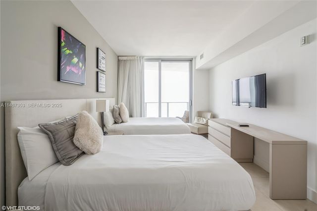 a spacious bedroom with a large bed and a flat screen tv