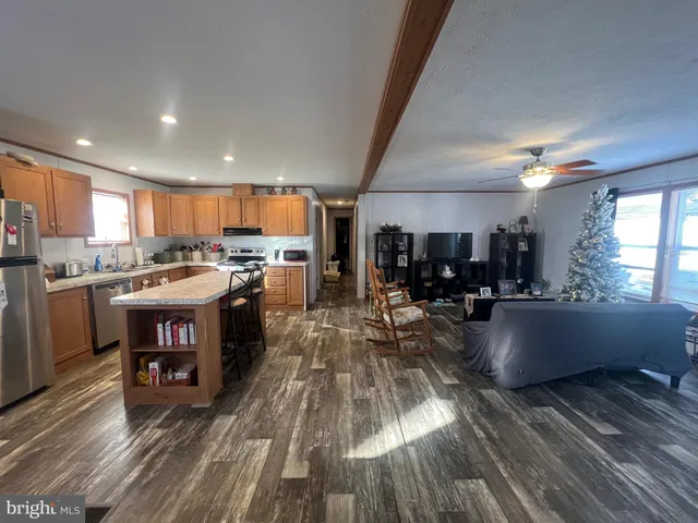 a kitchen with stainless steel appliances granite countertop a lot of cabinets and wooden floor