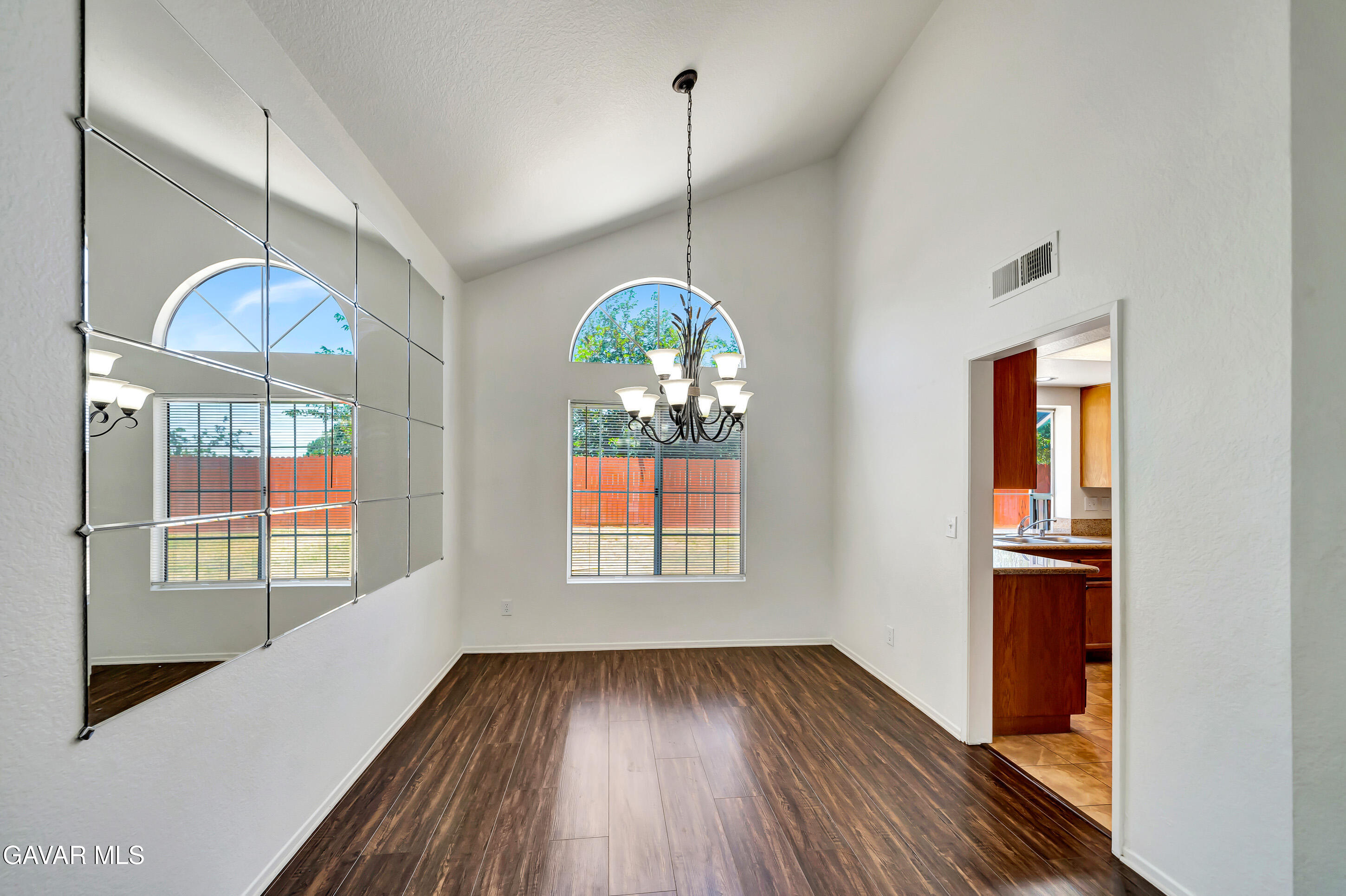 3115 Crowne Drive Palmdale, CA 93551 - Photo 12 of 51 a view of a room with wooden floor chandeliers and kitchen view