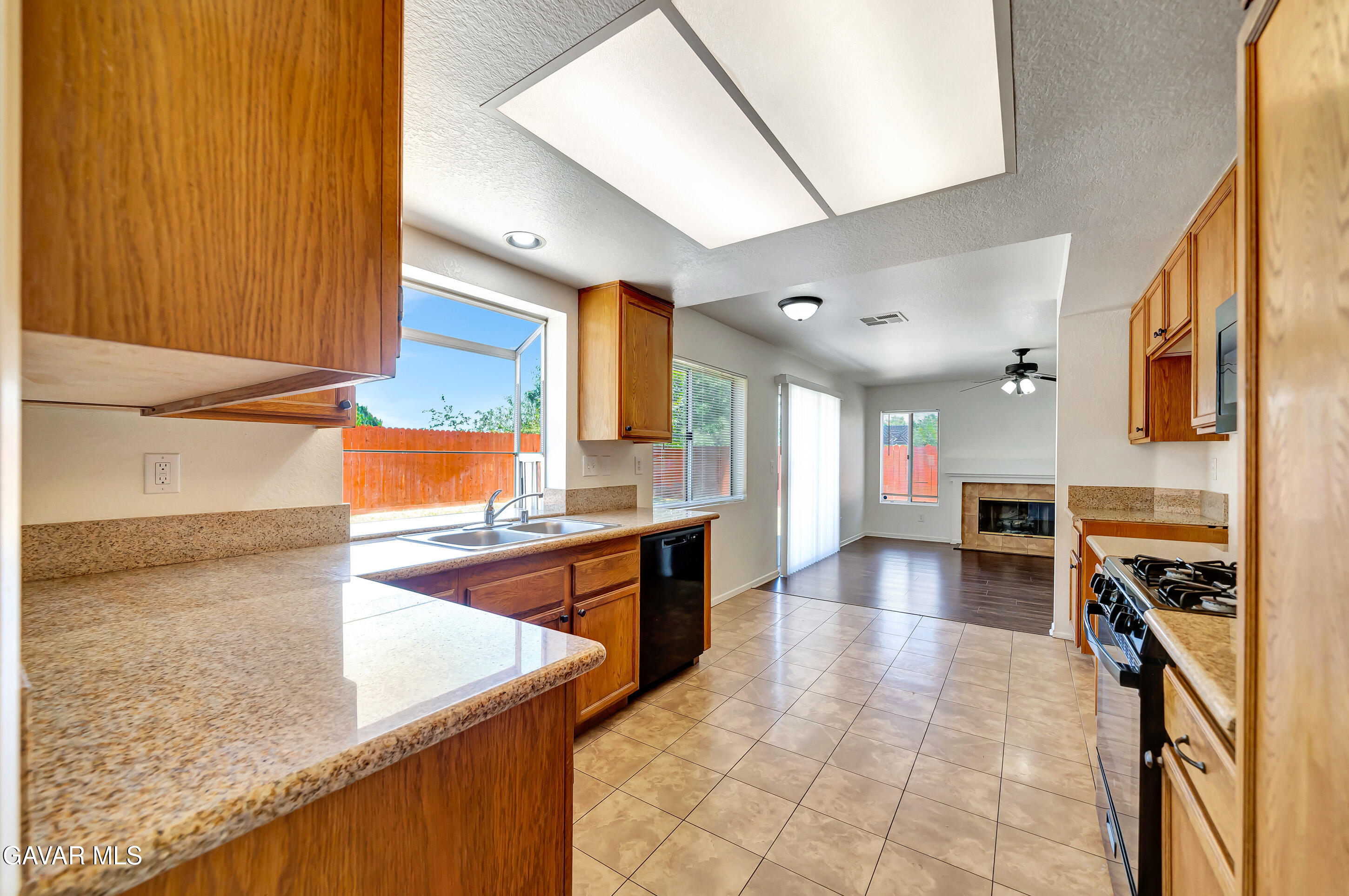 3115 Crowne Drive Palmdale, CA 93551 - Photo 13 of 51 a kitchen with stainless steel appliances granite countertop a sink stove and cabinets