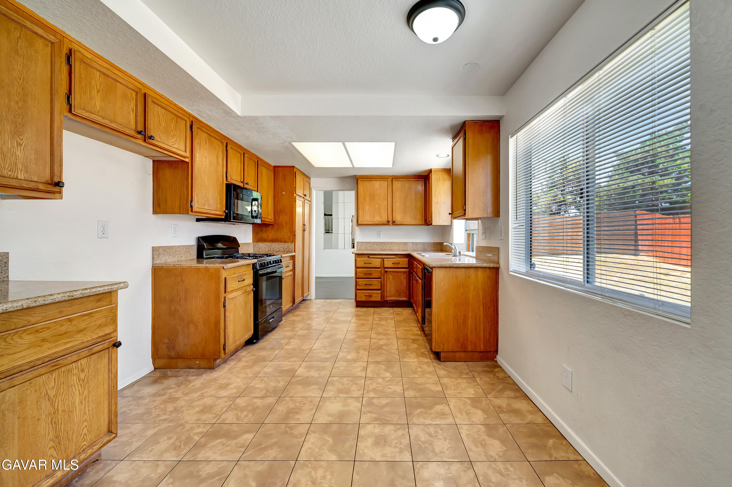 3115 Crowne Drive Palmdale, CA 93551 - Photo 14 of 51 a kitchen with a sink a counter top space stainless steel appliances cabinets and a window