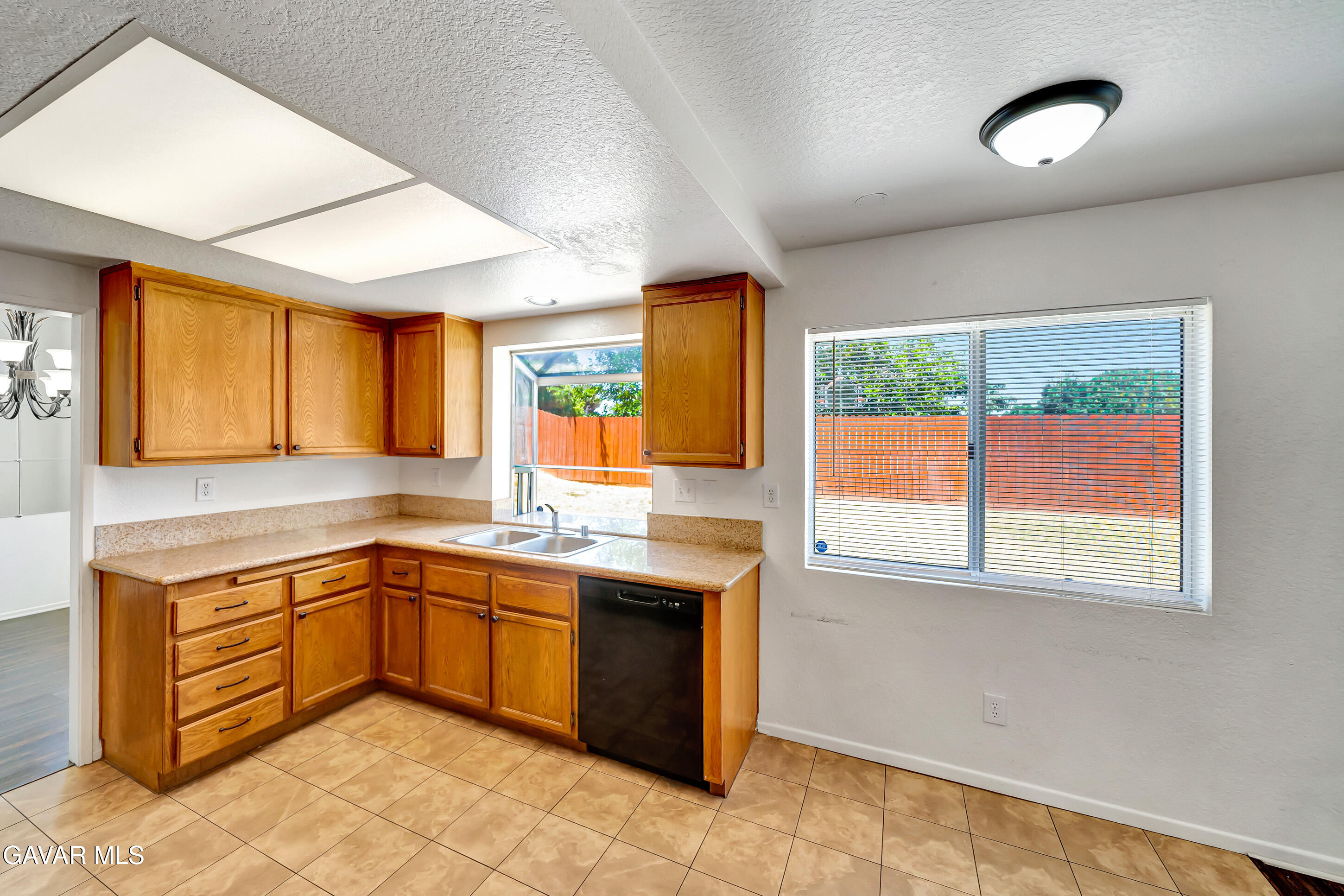3115 Crowne Drive Palmdale, CA 93551 - Photo 16 of 51 a kitchen with a sink window and cabinets