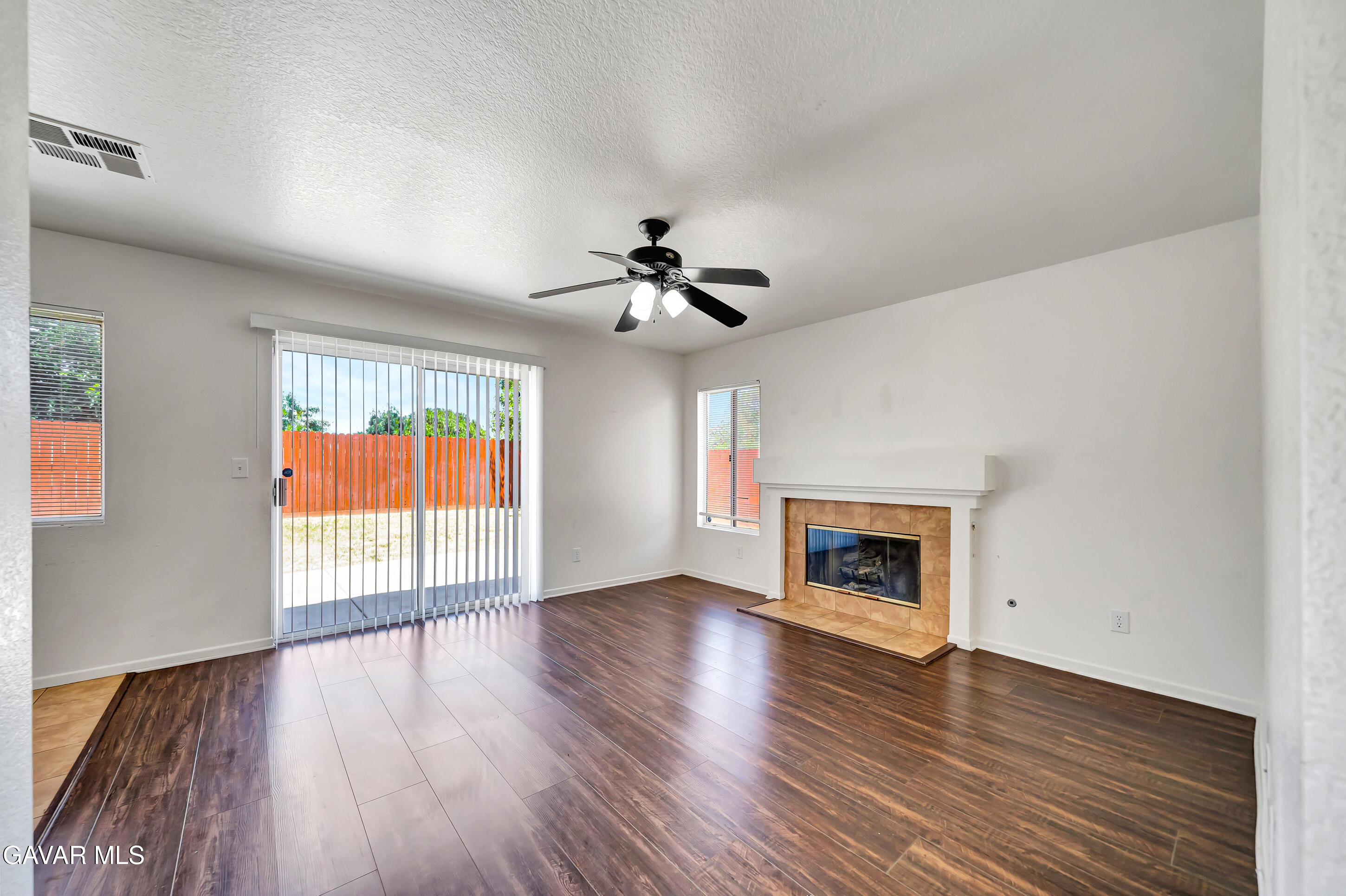 3115 Crowne Drive Palmdale, CA 93551 - Photo 21 of 51 an empty room with wooden floor fireplace and windows
