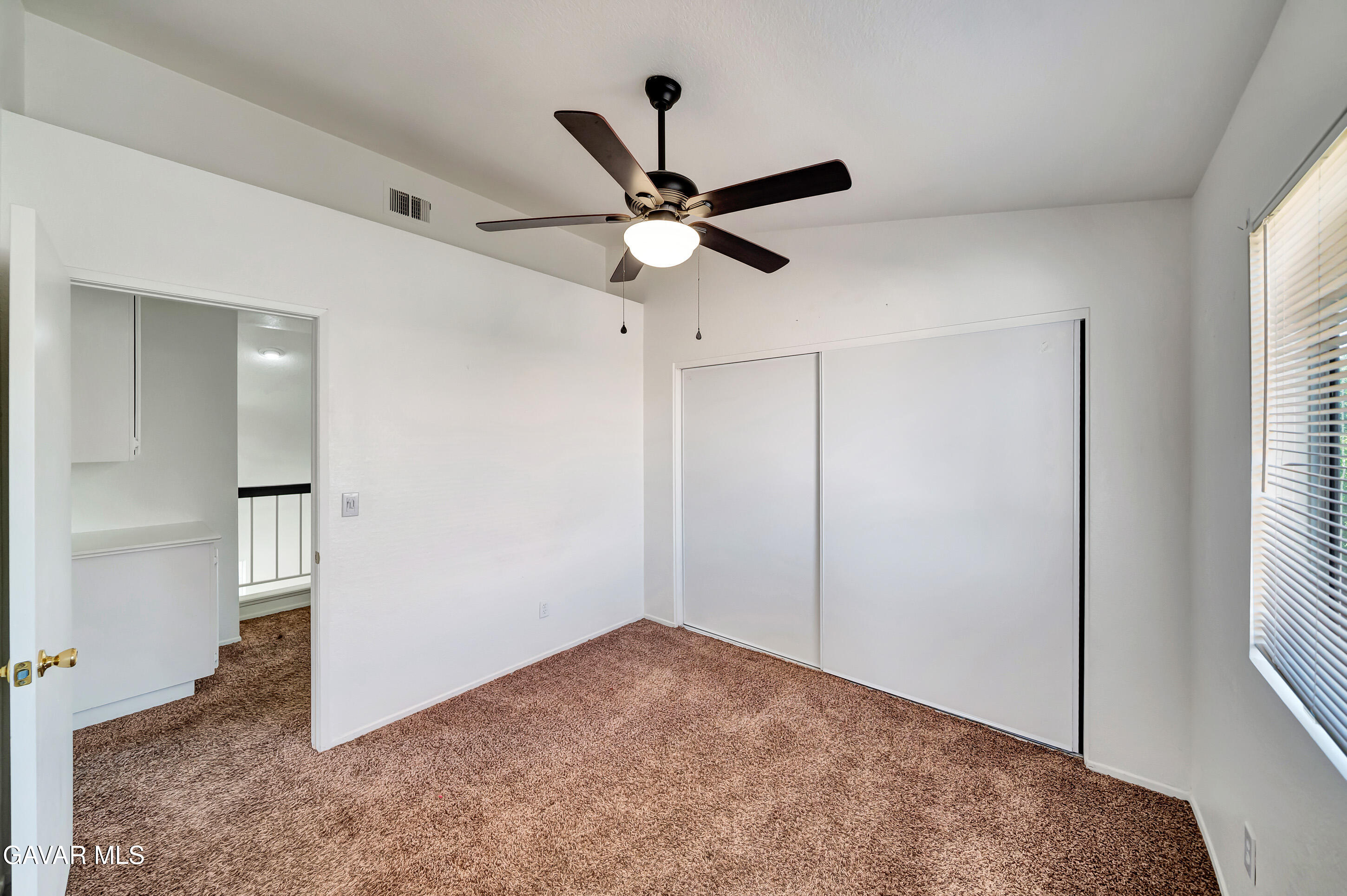3115 Crowne Drive Palmdale, CA 93551 - Photo 29 of 51 a view of a room with a ceiling fan and a window