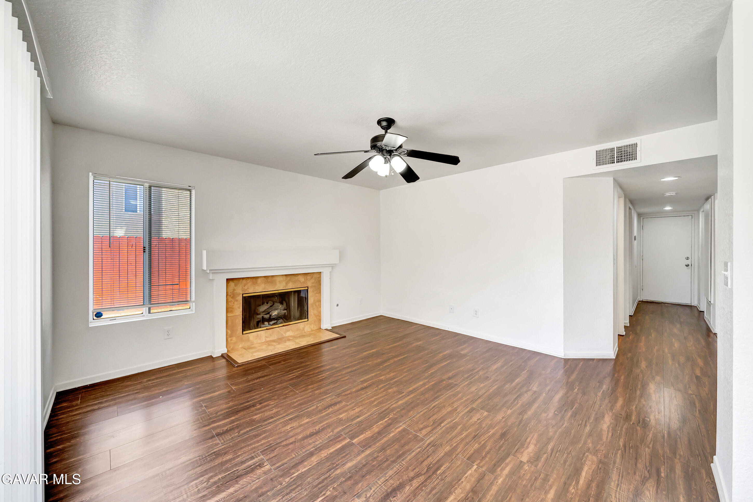 3115 Crowne Drive Palmdale, CA 93551 - Photo 32 of 51 a view of empty room with wooden floor fireplace and window