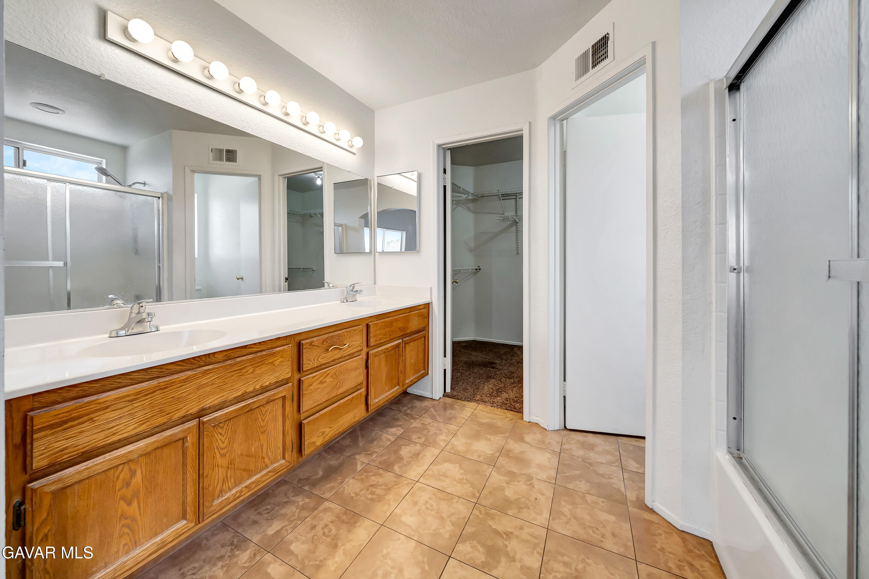 3115 Crowne Drive Palmdale, CA 93551 - Photo 44 of 51 a spacious bathroom with a shower sink and mirror