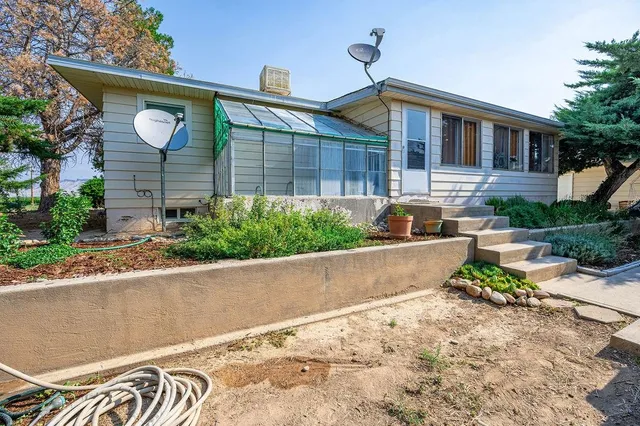 a front view of a house with a yard and potted plants