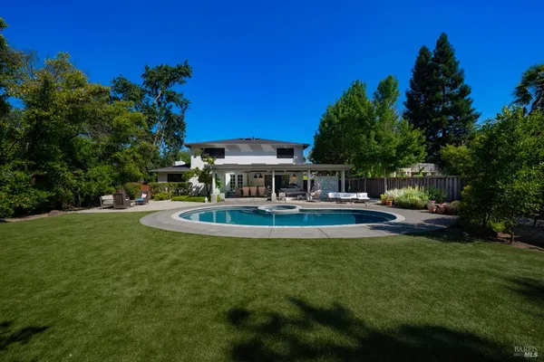 a view of a house with swimming pool and sitting area