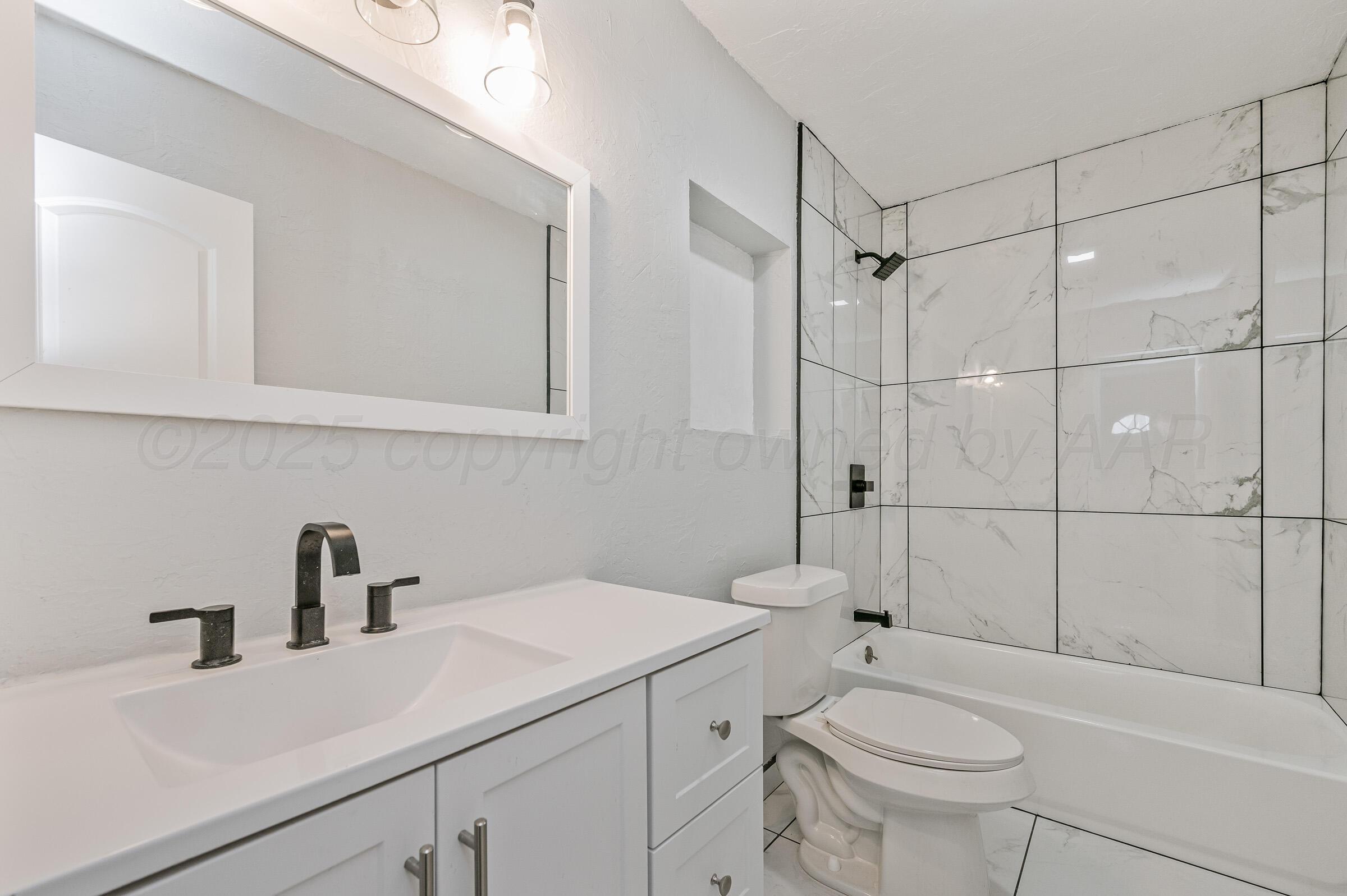 3705 South Polk Street Amarillo, TX 79110 - Photo 13 of 16 a bathroom with a sink a toilet and shower