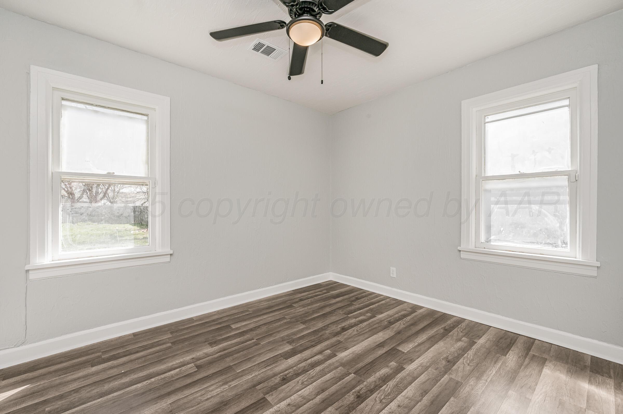 3705 South Polk Street Amarillo, TX 79110 - Photo 14 of 16 a view of empty room with wooden floor and fan