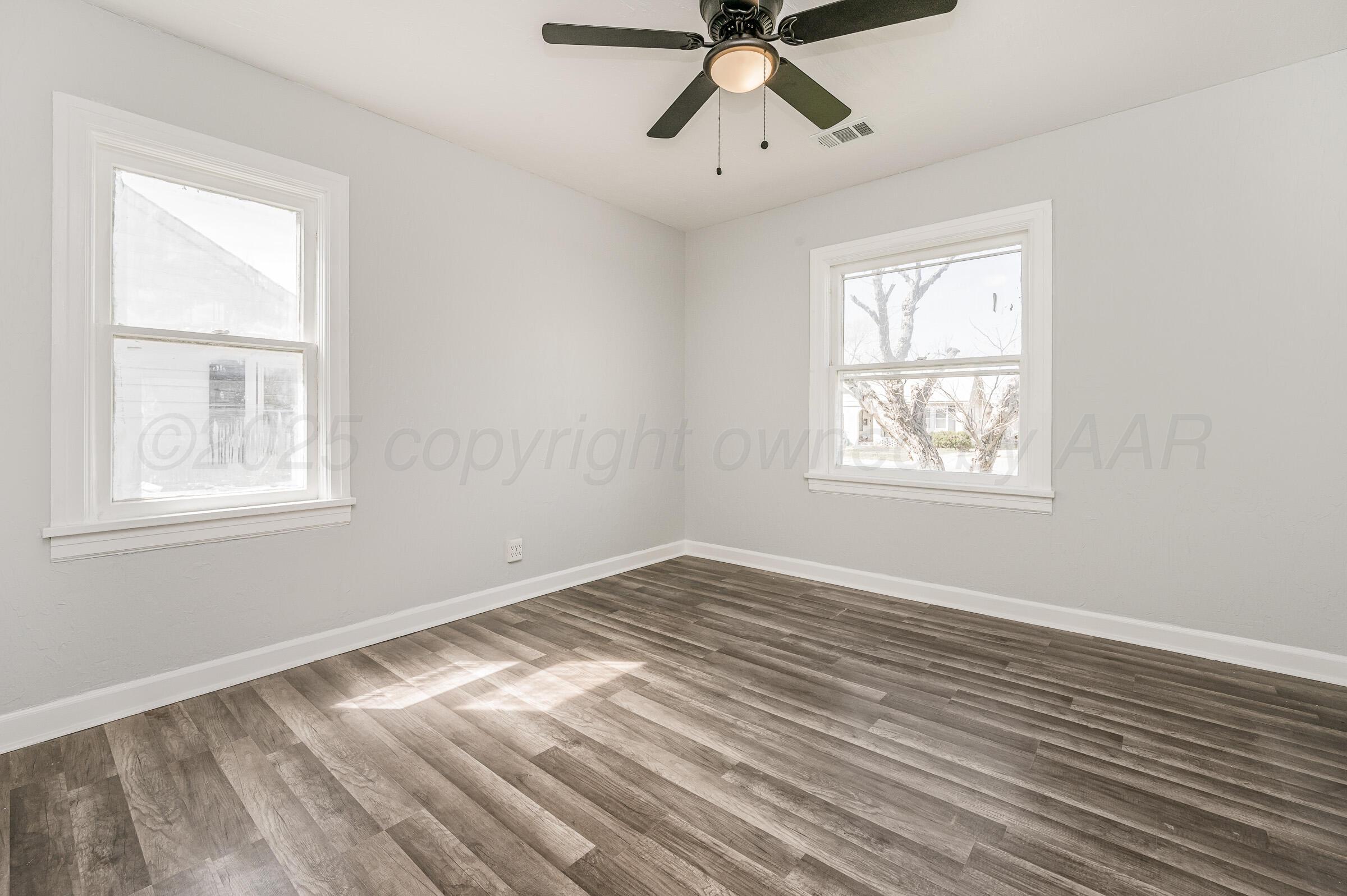 3705 South Polk Street Amarillo, TX 79110 - Photo 15 of 16 a view of empty room with wooden floor and fan