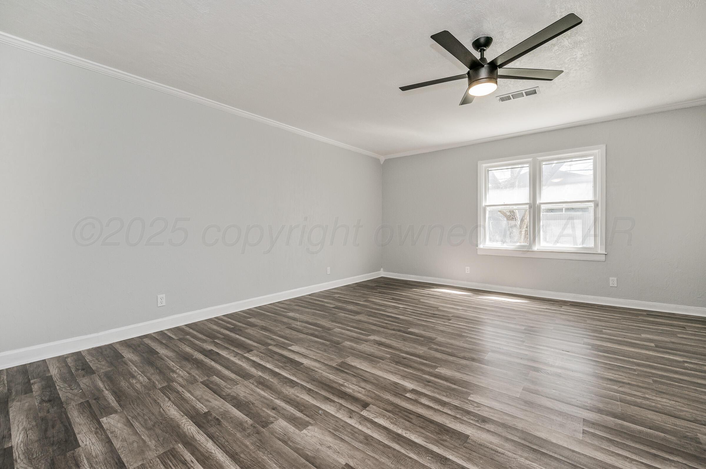 3705 South Polk Street Amarillo, TX 79110 - Photo 5 of 16 wooden floor in an empty room with a window