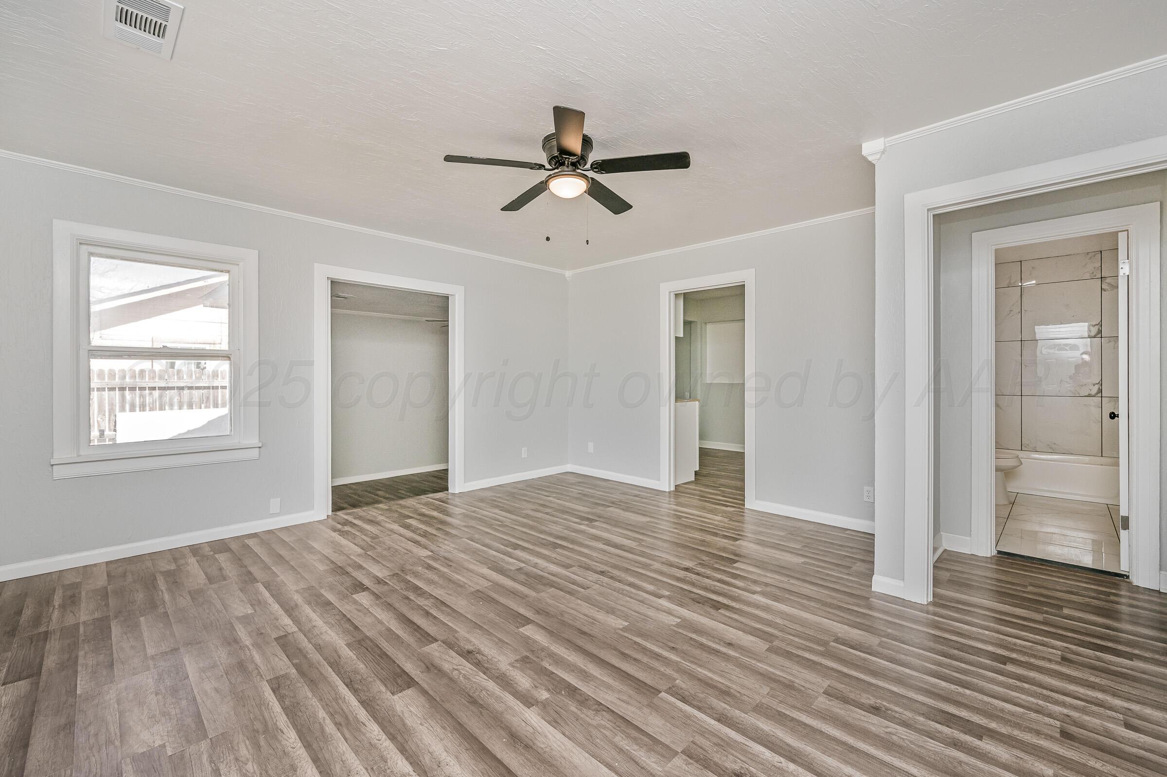 3705 South Polk Street Amarillo, TX 79110 - Photo 7 of 16 a view of empty room with wooden floor and fan