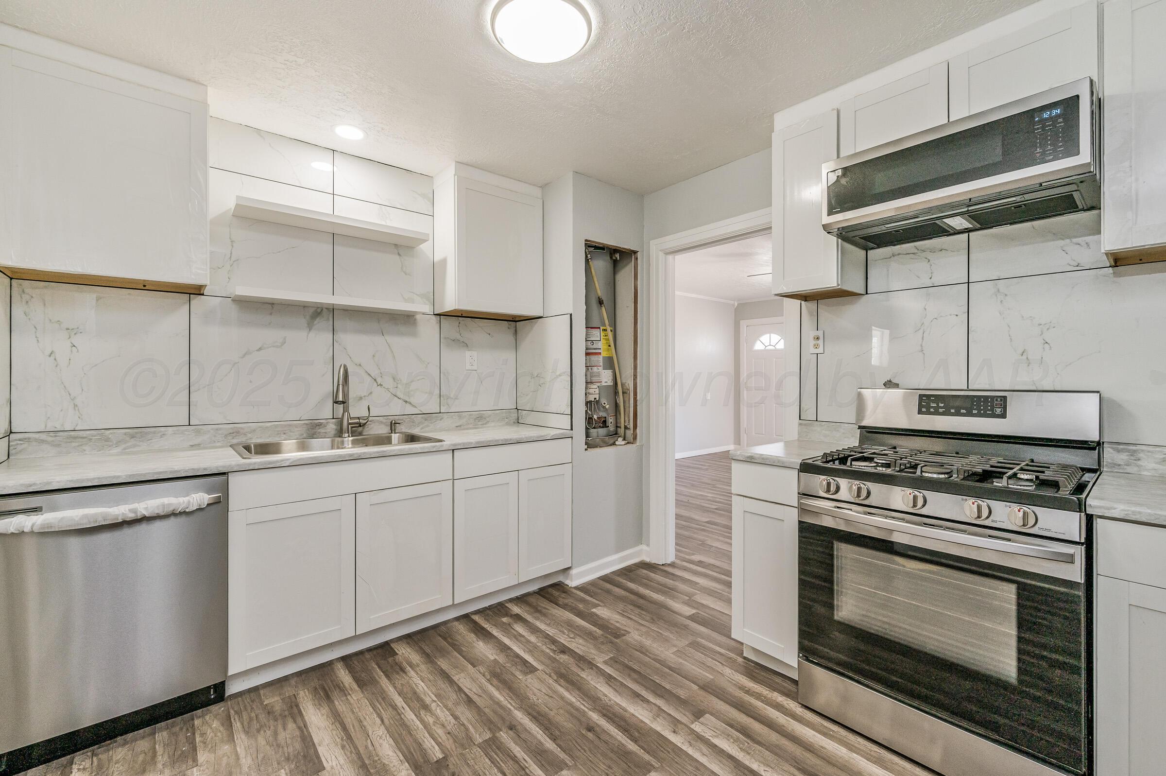 3705 South Polk Street Amarillo, TX 79110 - Photo 10 of 16 a kitchen with stainless steel appliances granite countertop a stove and a sink