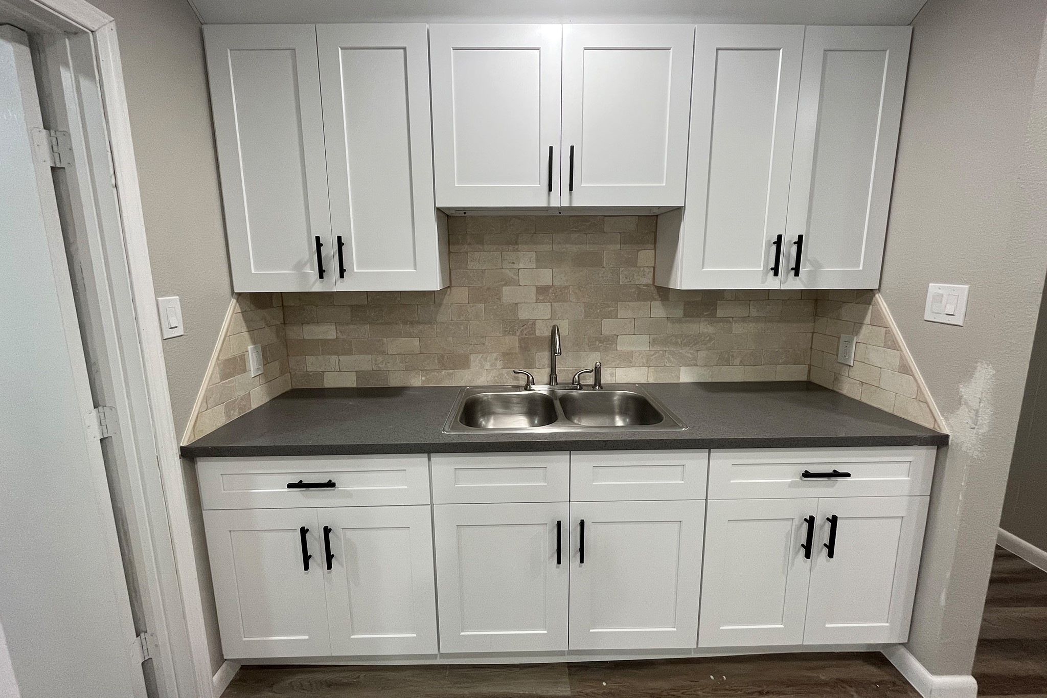1409 20th Street Huntsville, TX 77340 - Photo 3 of 9 a kitchen with granite countertop white cabinets and a sink
