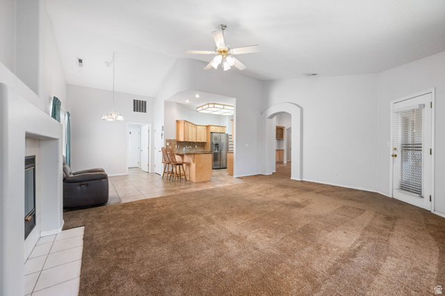 39 North Valley View Drive, Unit 51 St. George, UT 84770 - Photo 9 of 25 Spacious living area featuring vaulted ceilings, a built-in fireplace with a tiled hearth, and carpeted flooring