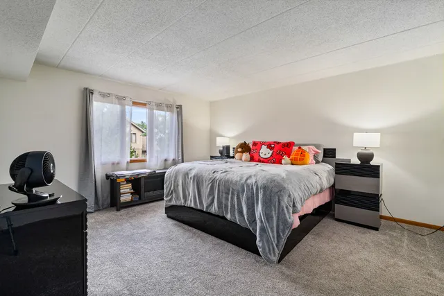a spacious bedroom with a bed and a computer on the desk