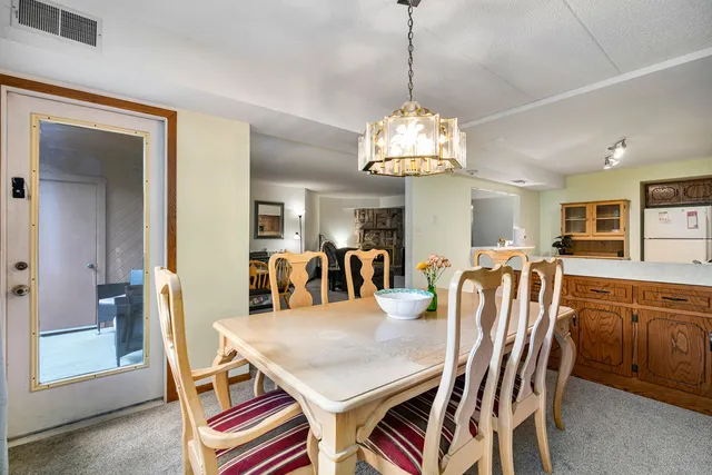 a dining room with furniture a chandelier and window