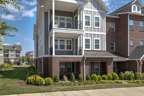 a front view of a residential apartment building with a yard