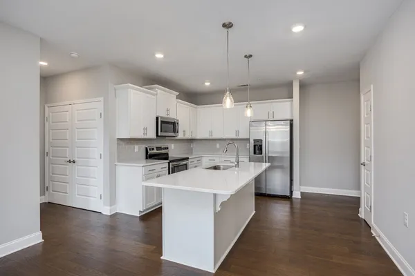 a large kitchen with stainless steel appliances kitchen island a large counter top and a sink