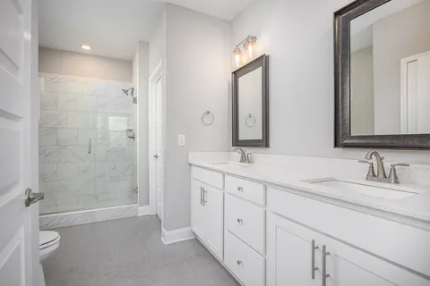 a bathroom with a double vanity sink mirror double and shower