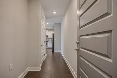 a view of hallway with stairs and wooden floor