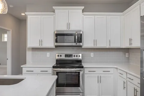 a kitchen with white cabinets and stainless steel appliances