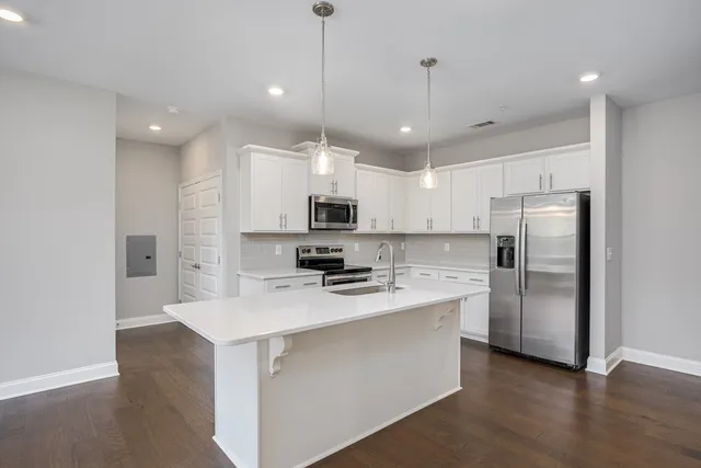 a kitchen with kitchen island a sink stainless steel appliances and cabinets