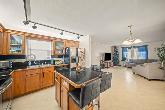 a kitchen with granite countertop a sink counter top space and stainless steel appliances