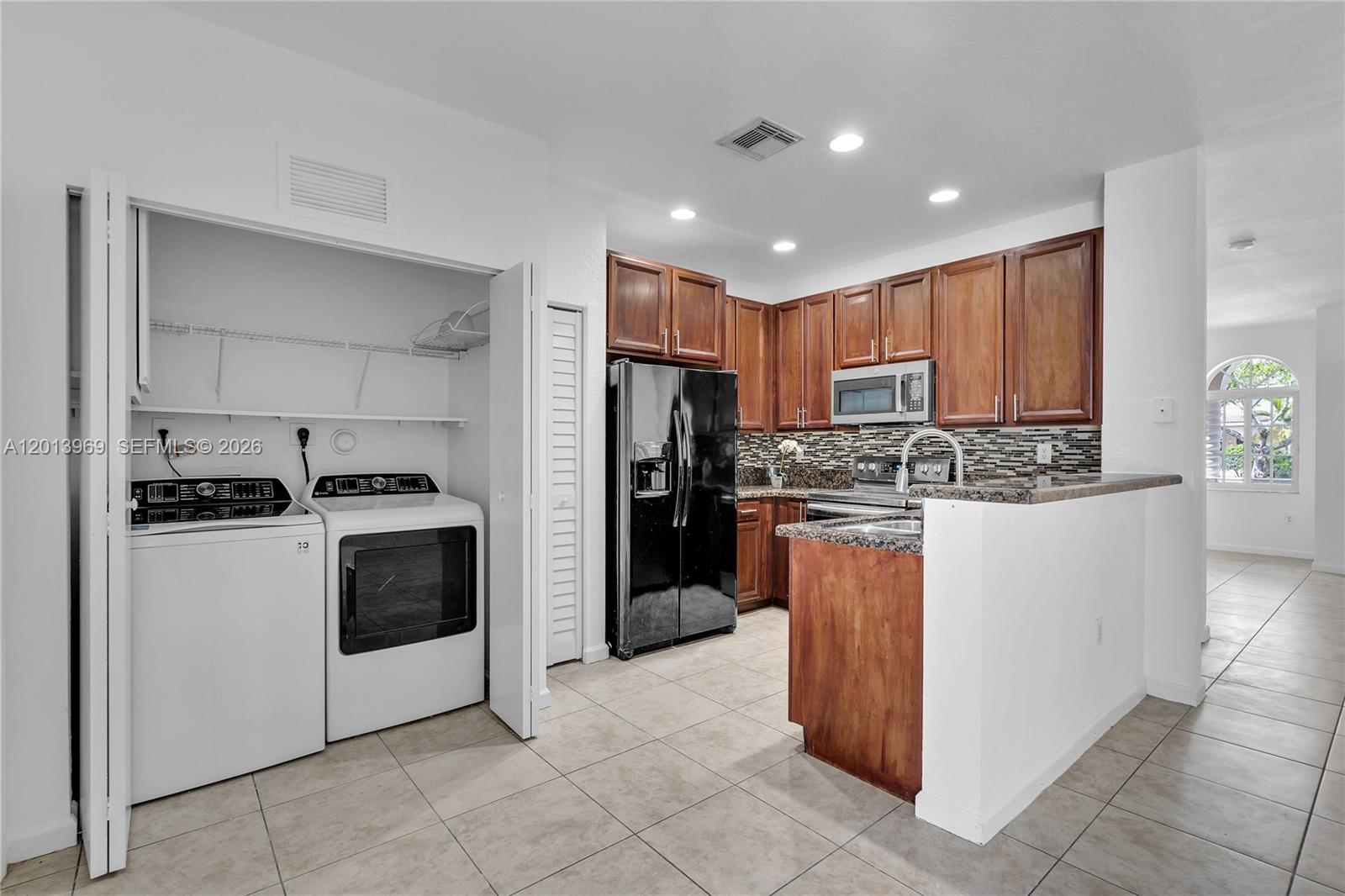 14044 Southwest 273rd Lane, Unit 14044 Homestead, FL 33032 - Photo 12 of 44 a kitchen with a refrigerator and a stove top oven