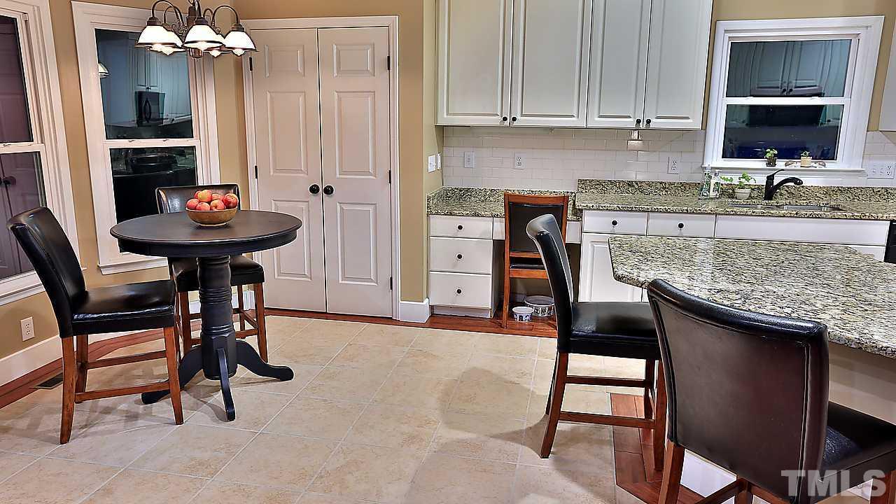 8536 Yucca Trail Raleigh, NC 27615 - Photo 14 of 23 a kitchen with stainless steel appliances granite countertop a sink white cabinets and chairs